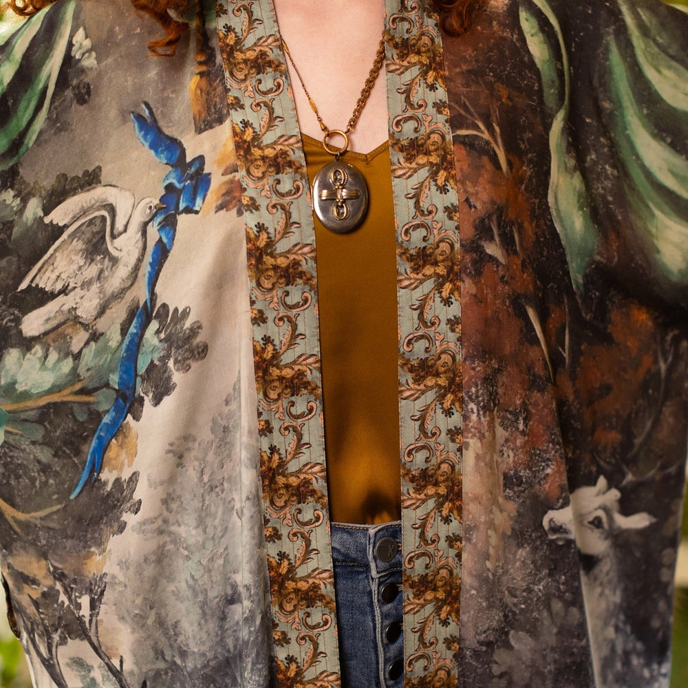 
                  
                    Model wearing the Theatre of Dreams Opera Duster featuring whimsical birds, love letters, and richly painted curtains by artist Jennifer Lanne – Market of Stars
                  
                