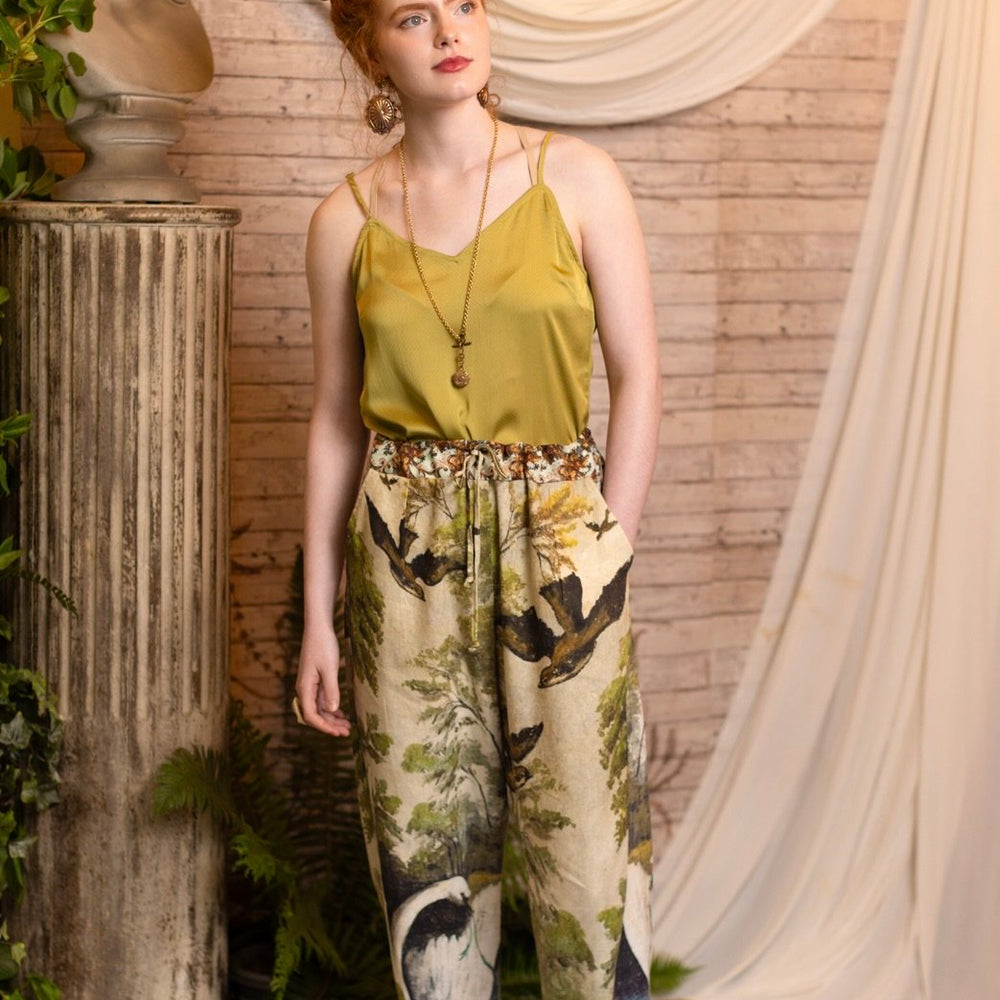 
                  
                    Model wearing Theatre of Dreams Artist Pants with lantern-hem silhouette featuring antique landscape, swan, and painted birds by artist Jennifer Lanne
                  
                