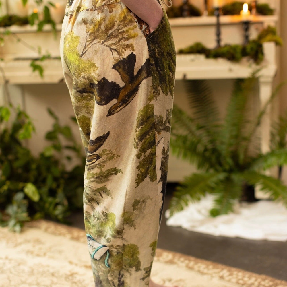 
                  
                    Model wearing Theatre of Dreams Artist Pants with lantern-hem silhouette featuring antique landscape, swan, and painted birds by artist Jennifer Lanne
                  
                