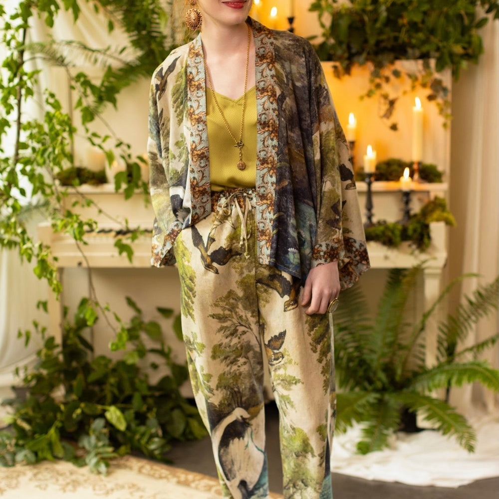 
                  
                    Model wearing Theatre of Dreams Artist Pants with lantern-hem silhouette featuring antique landscape, swan, and painted birds by artist Jennifer Lanne
                  
                