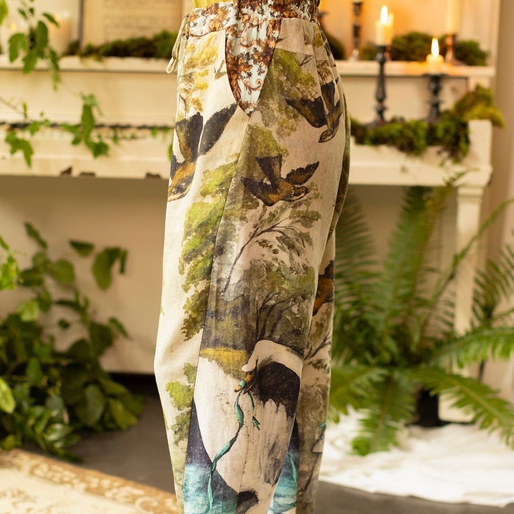 
                  
                    Model wearing Theatre of Dreams Artist Pants with lantern-hem silhouette featuring antique landscape, swan, and painted birds by artist Jennifer Lanne
                  
                