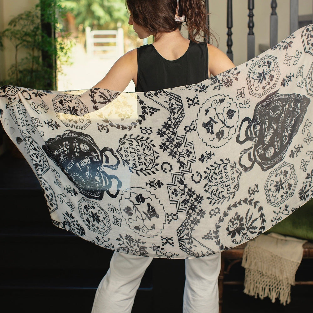Model wearing the Token of Love scarf featuring black and ivory printed antique cross-stitch – Market of Stars