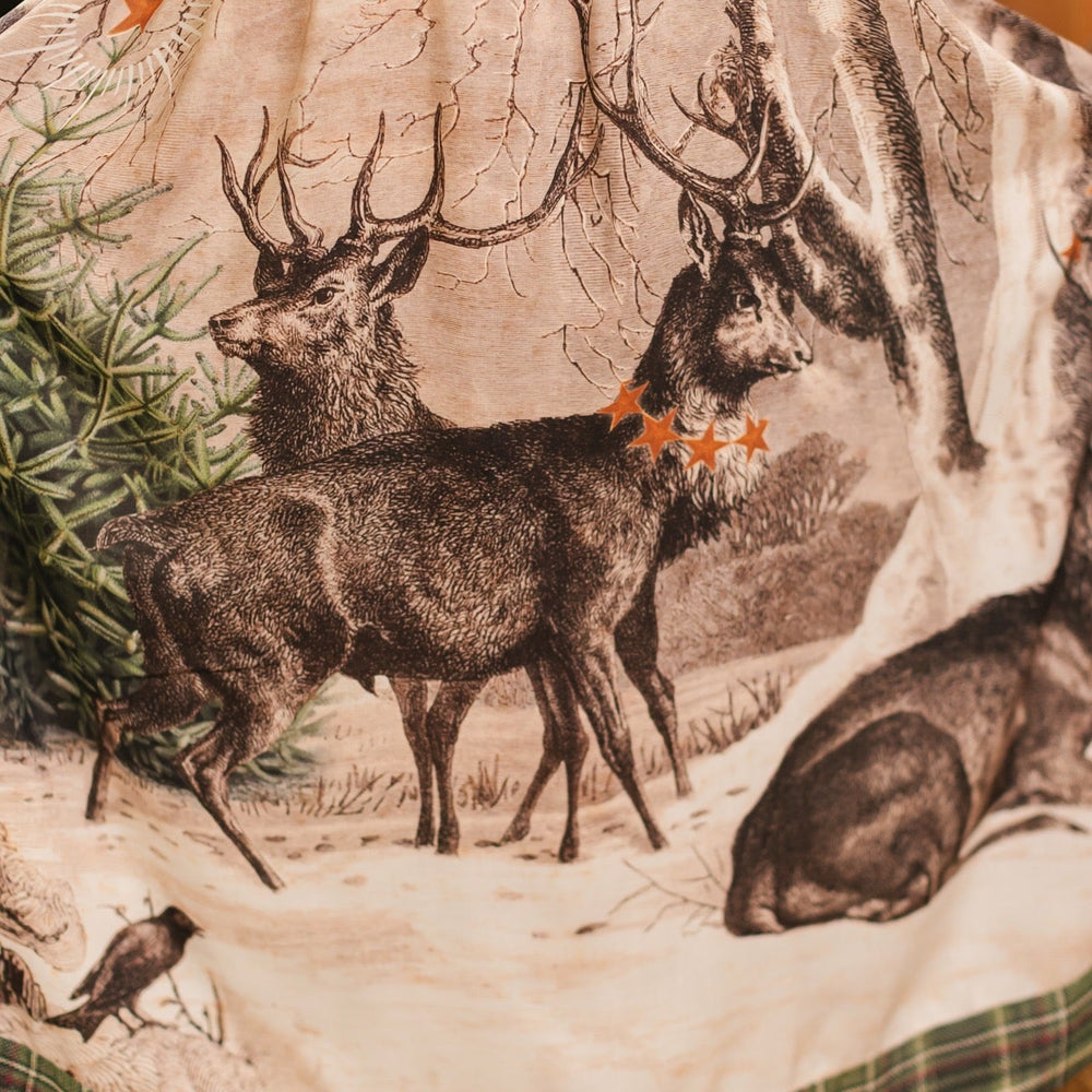 
                  
                    Model wearing a bamboo viscose maxi slip dress with Victorian-era images from holiday greeting cards — including reindeer in the snow, a little fir tree, golden stars, and traditional plaid trim - Market of Stars
                  
                