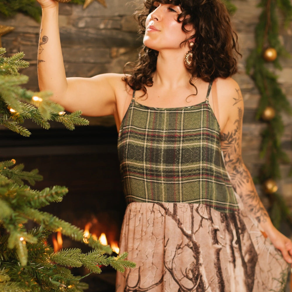 
                  
                    Model wearing a bamboo viscose maxi slip dress with Victorian-era images from holiday greeting cards — including reindeer in the snow, a little fir tree, golden stars, and traditional plaid trim - Market of Stars
                  
                