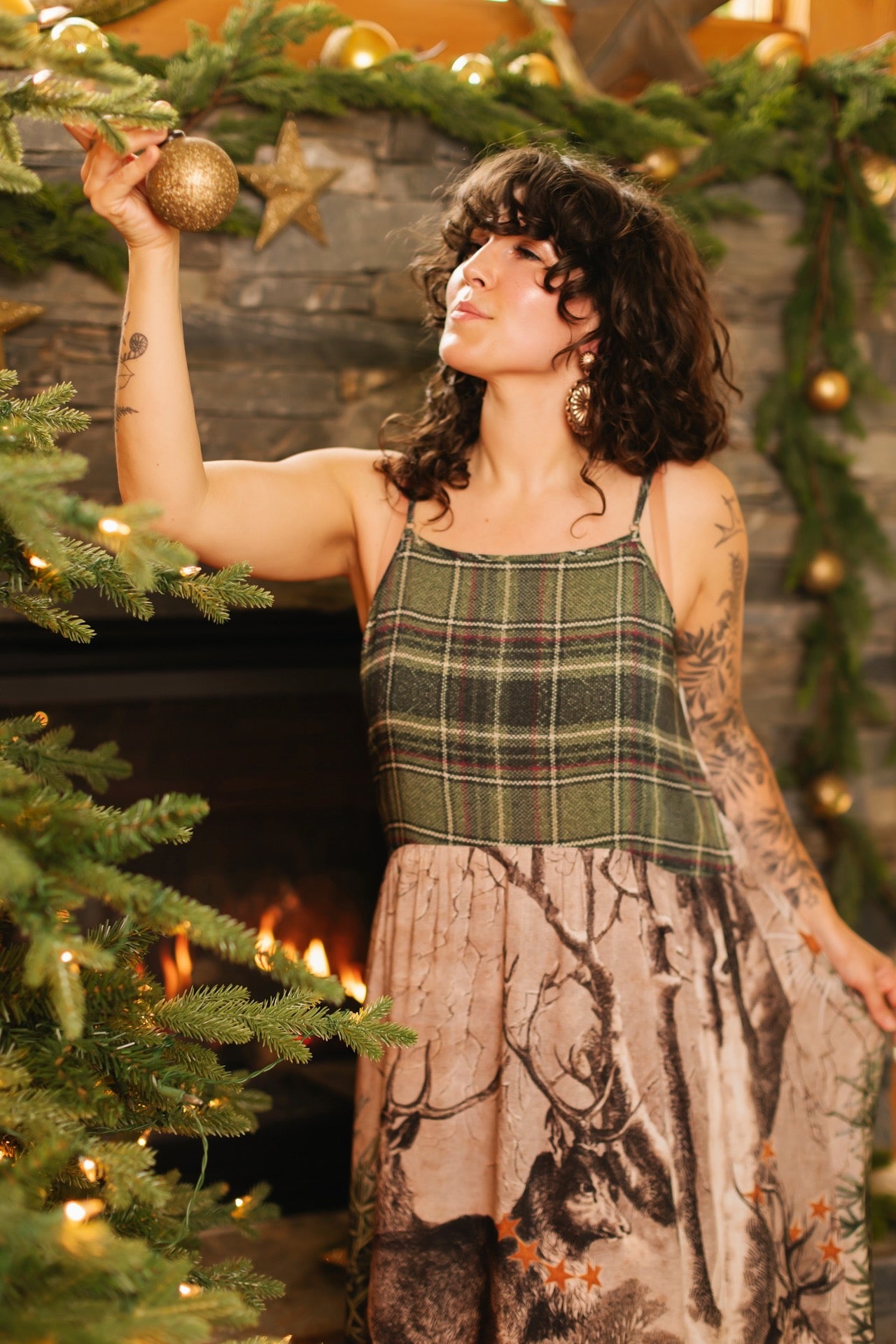 Model wearing a bamboo viscose maxi slip dress with Victorian-era images from holiday greeting cards — including reindeer in the snow, a little fir tree, golden stars, and traditional plaid trim - Market of Stars