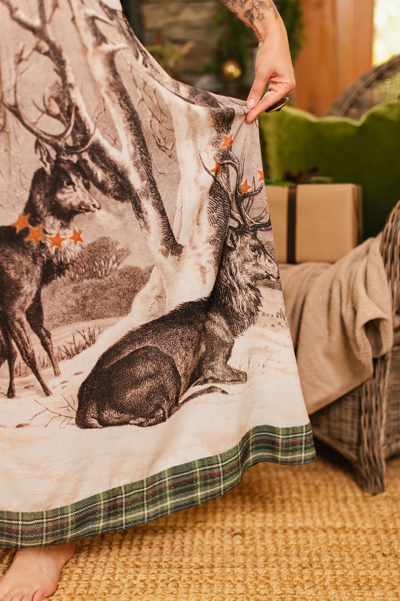 Model wearing a bamboo viscose maxi slip dress with Victorian-era images from holiday greeting cards — including reindeer in the snow, a little fir tree, golden stars, and traditional plaid trim - Market of Stars