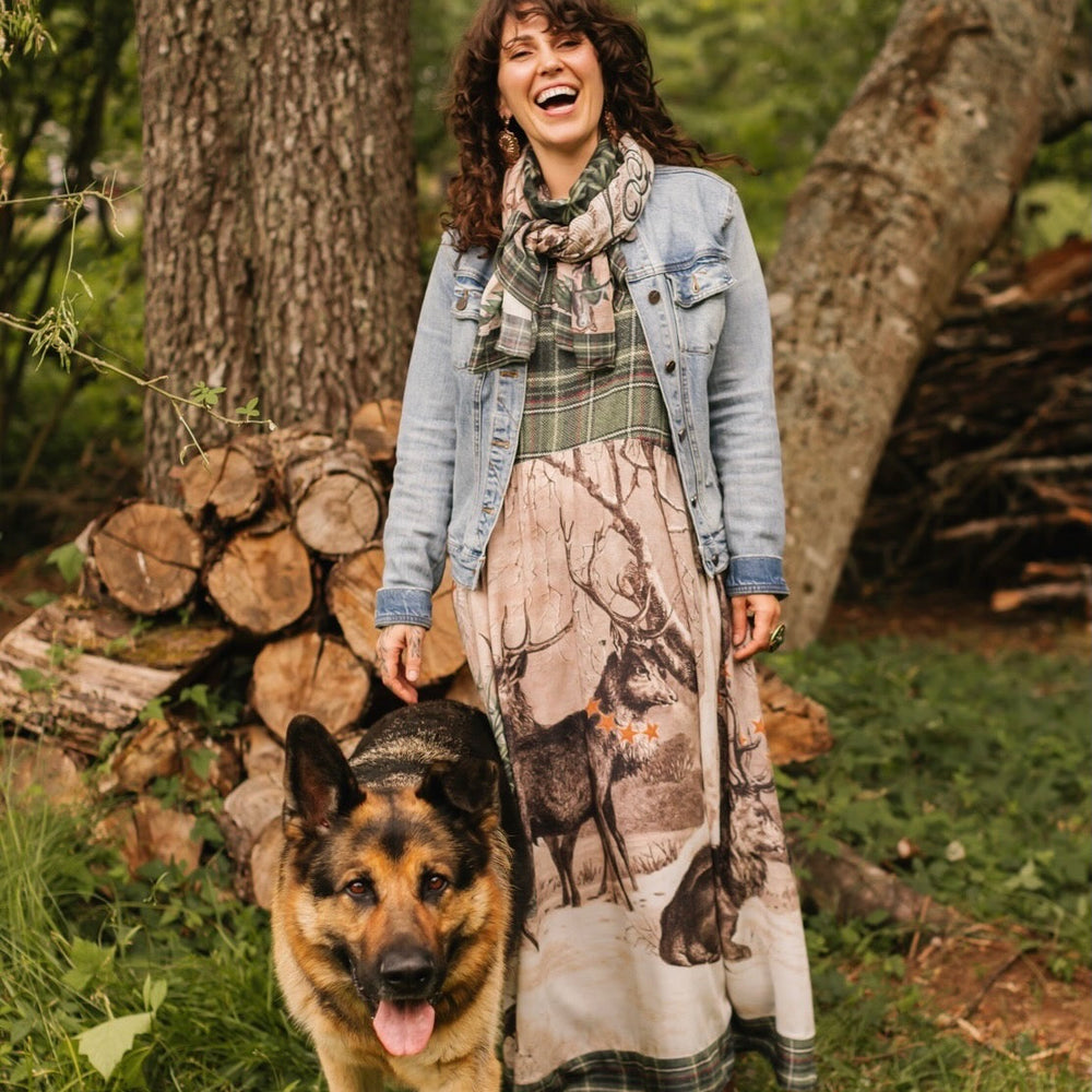 
                  
                    Model wearing a bamboo viscose maxi slip dress with Victorian-era images from holiday greeting cards — including reindeer in the snow, a little fir tree, golden stars, and traditional plaid trim - Market of Stars
                  
                