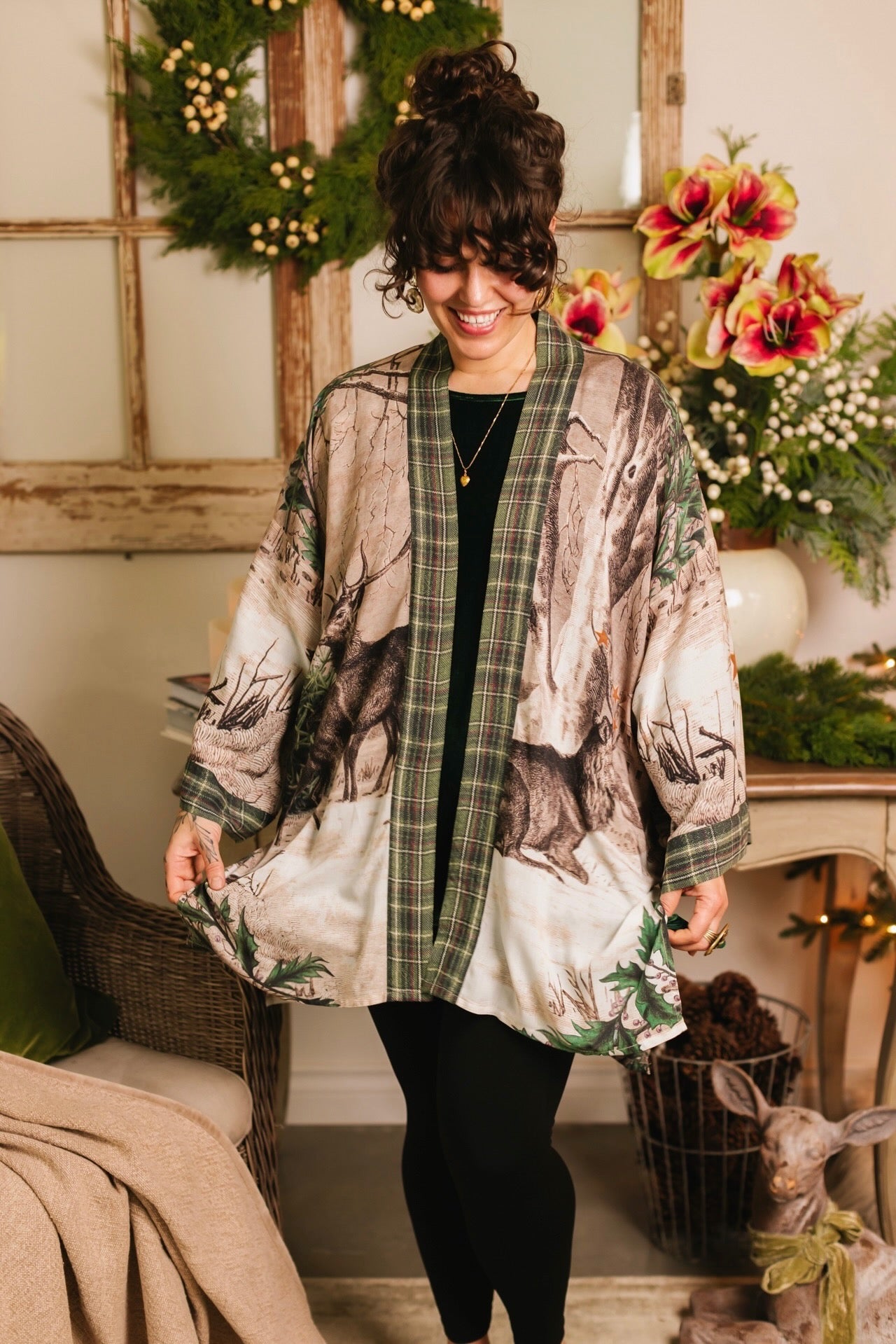 Model wearing a bamboo viscose mid-length duster with Victorian-era images from holiday greeting cards — including reindeer in the snow, a little fir tree, golden stars, and traditional plaid trim - Market of Stars