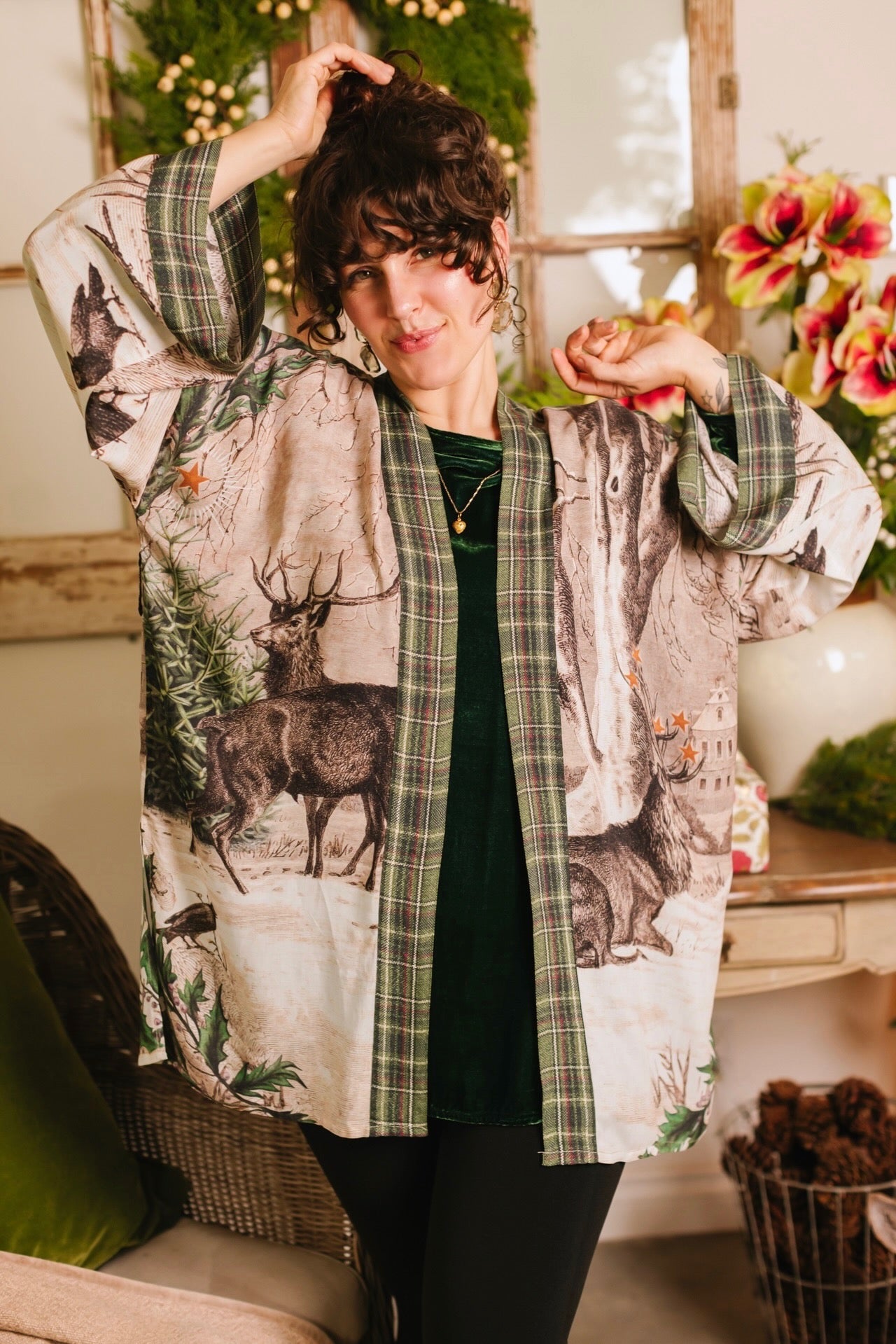 Model wearing a bamboo viscose mid-length duster with Victorian-era images from holiday greeting cards — including reindeer in the snow, a little fir tree, golden stars, and traditional plaid trim - Market of Stars