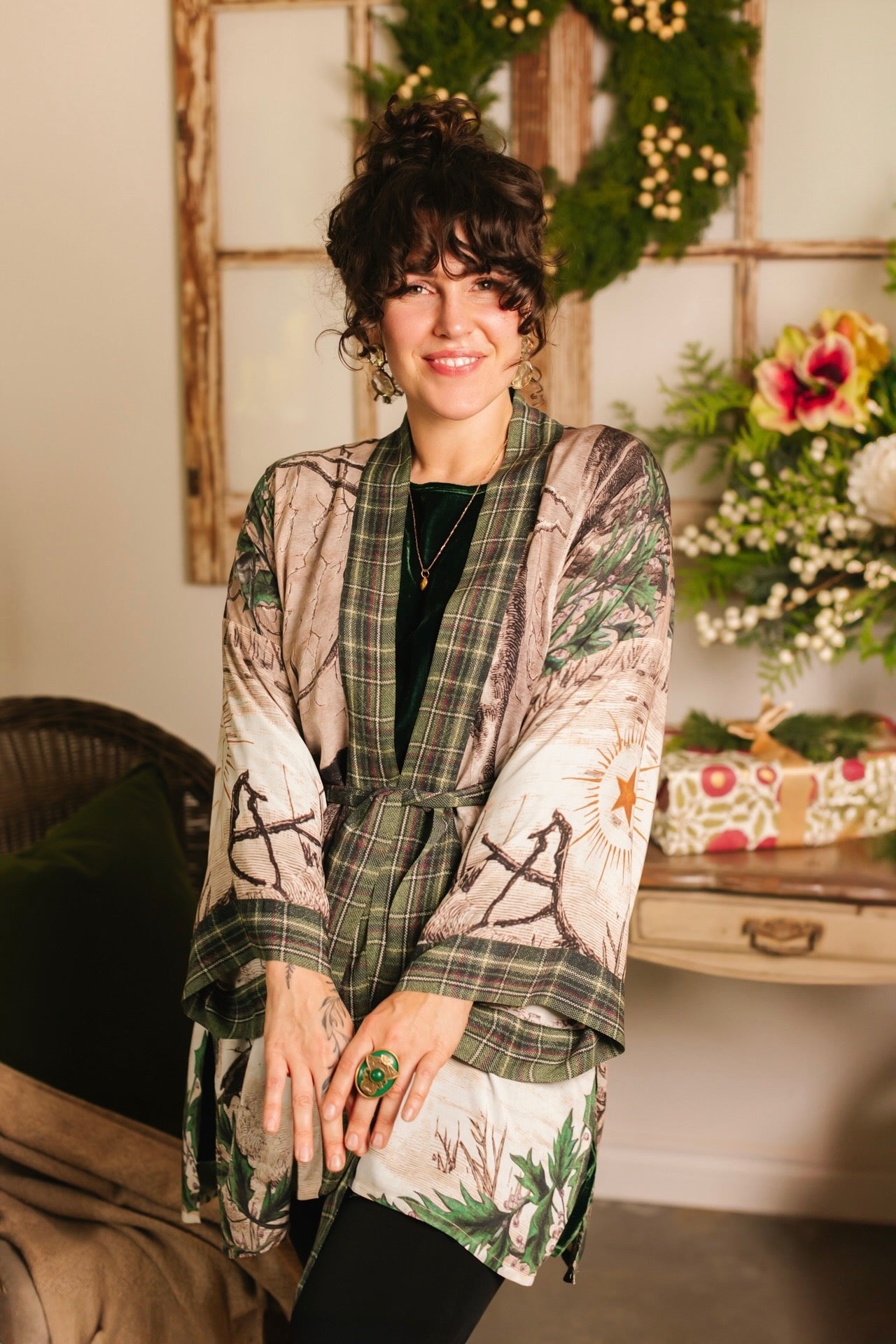 Model wearing a bamboo viscose mid-length duster with Victorian-era images from holiday greeting cards — including reindeer in the snow, a little fir tree, golden stars, and traditional plaid trim - Market of Stars