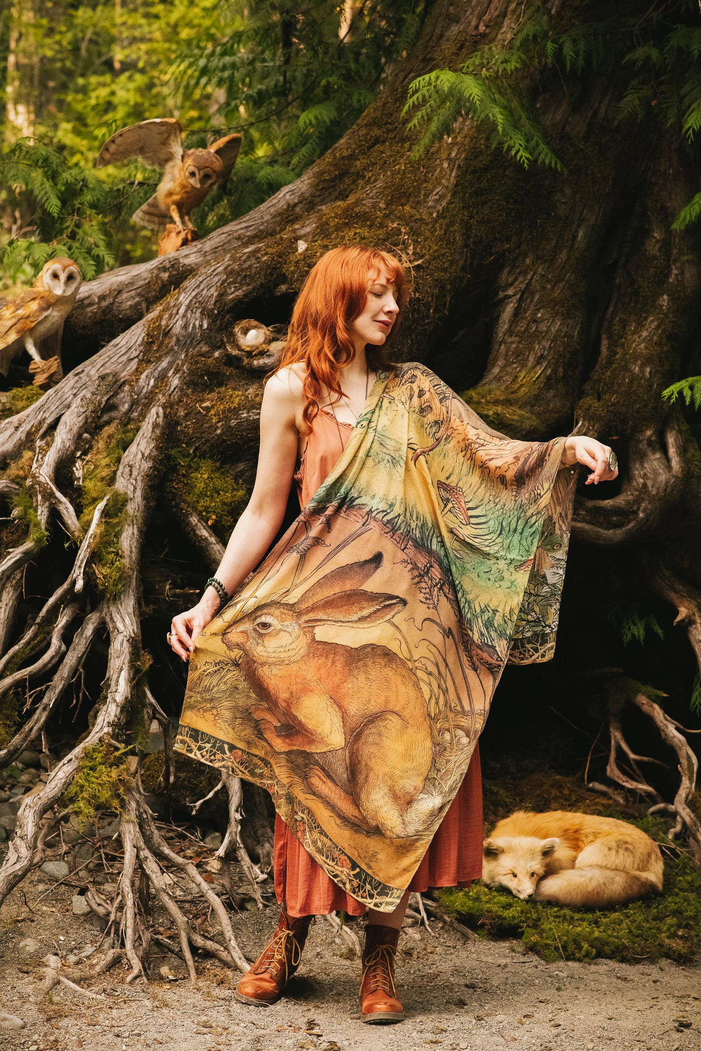 Model wearing a bamboo-viscose scarf where a noble rabbit rests deep within an underground burrow, surrounded by the warmth and safety of the earth. Created in collaboration with Charles van Sandwyck - Market of Stars