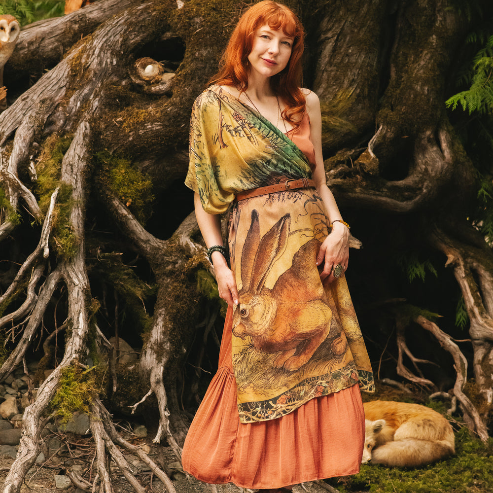 
                  
                    Model wearing a bamboo-viscose scarf where a noble rabbit rests deep within an underground burrow, surrounded by the warmth and safety of the earth. Created in collaboration with Charles van Sandwyck - Market of Stars
                  
                