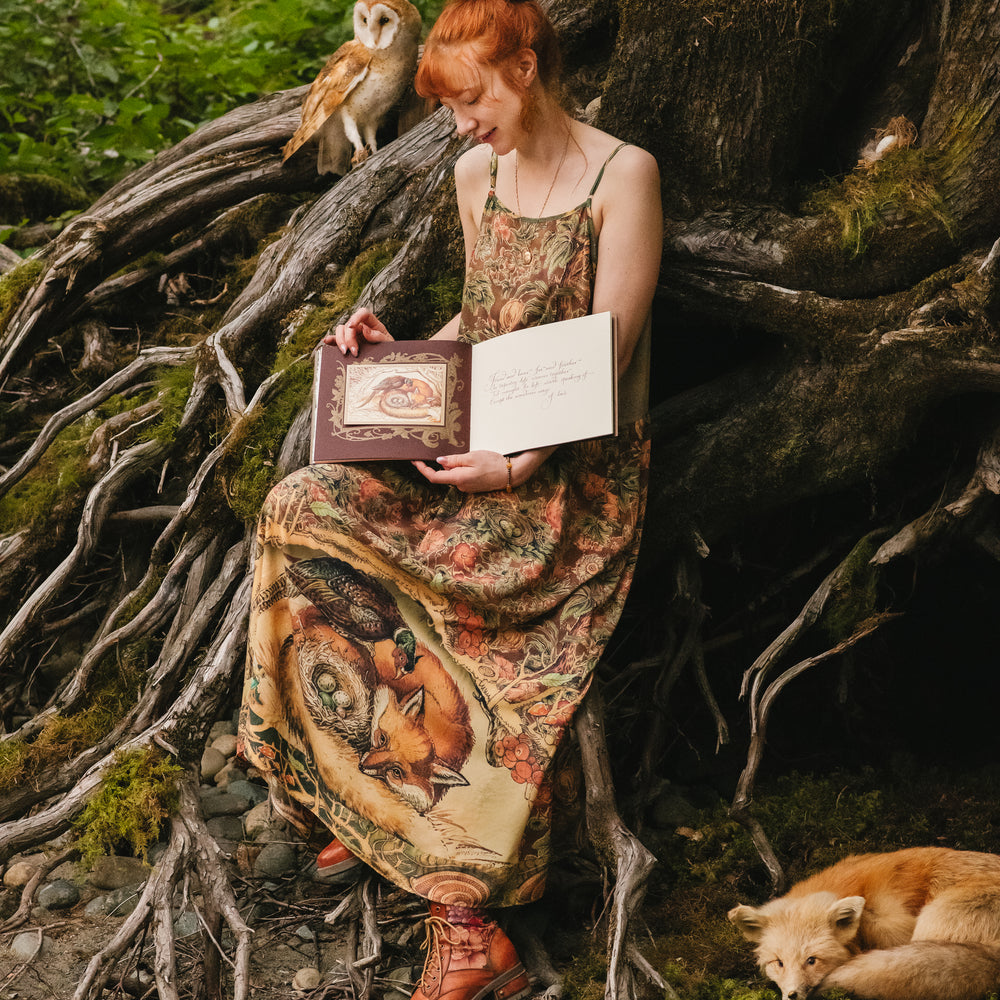 
                  
                    Model wearing a bamboo-viscose maxi length slip dress where even the unlikeliest of friends...a fox and a pheasant...find warmth in each other’s company. Created in collaboration with Charles van Sandwyck - Market of Stars
                  
                