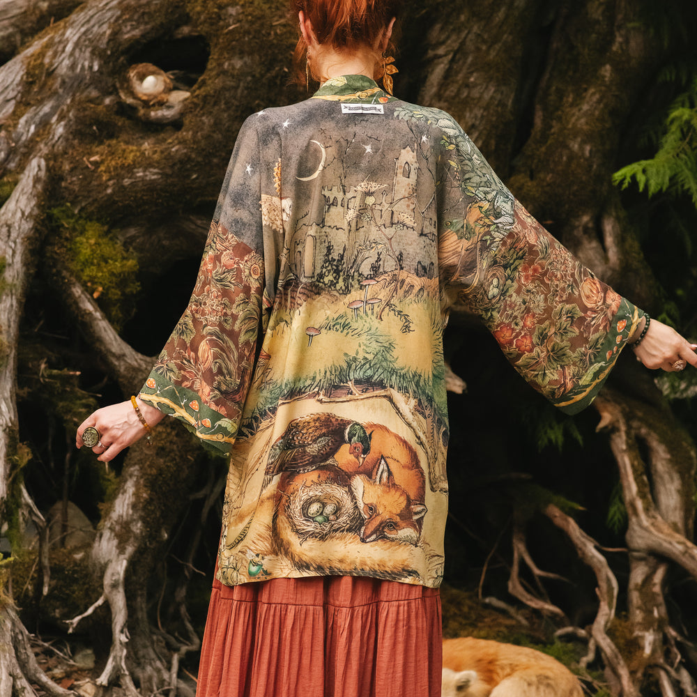
                  
                    Model wearing a bamboo-viscose mid-length duster kimono robe where even the unlikeliest of friends...a fox and a pheasant...find warmth in each other’s company. Created in collaboration with Charles van Sandwyck - Market of Stars
                  
                